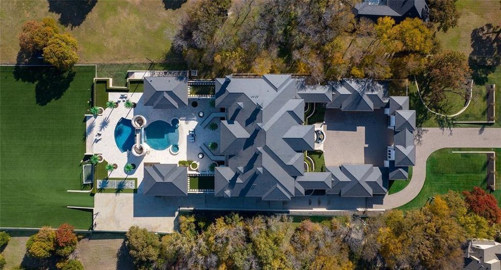 A view of the property from above, looking down at the 31,000 square foot home, pool, and yard.