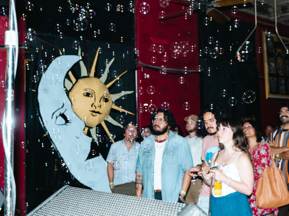 An audience watching the 2024 Solar Flare Music Festival next to a sun and moon decoration.