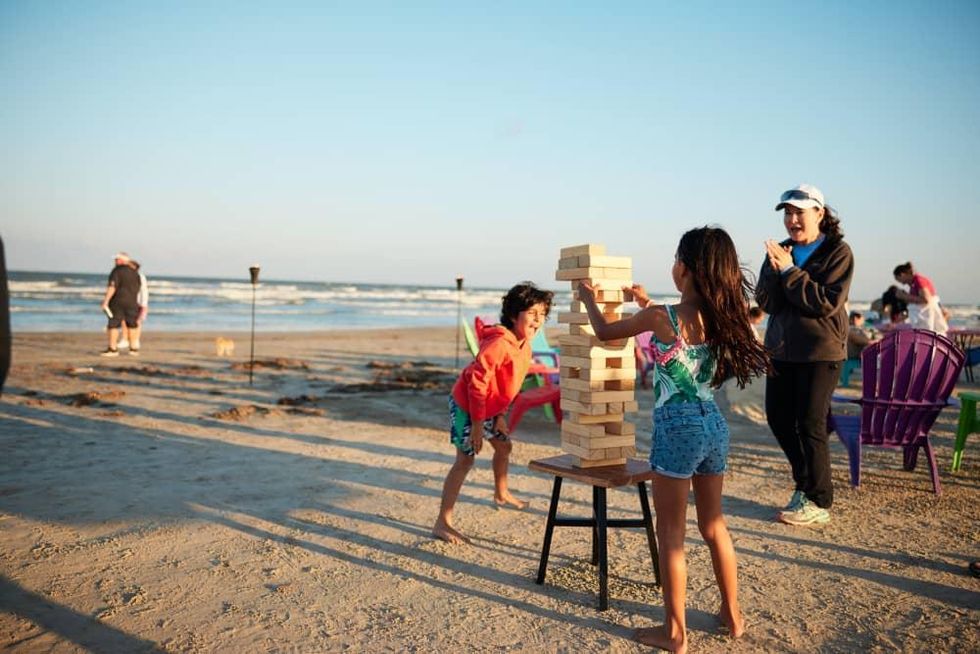 Family playing Jenga on the beach