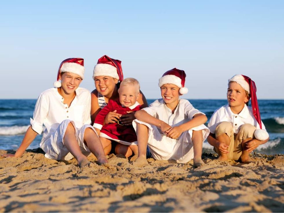 Kids on the beach wearing Santa hats