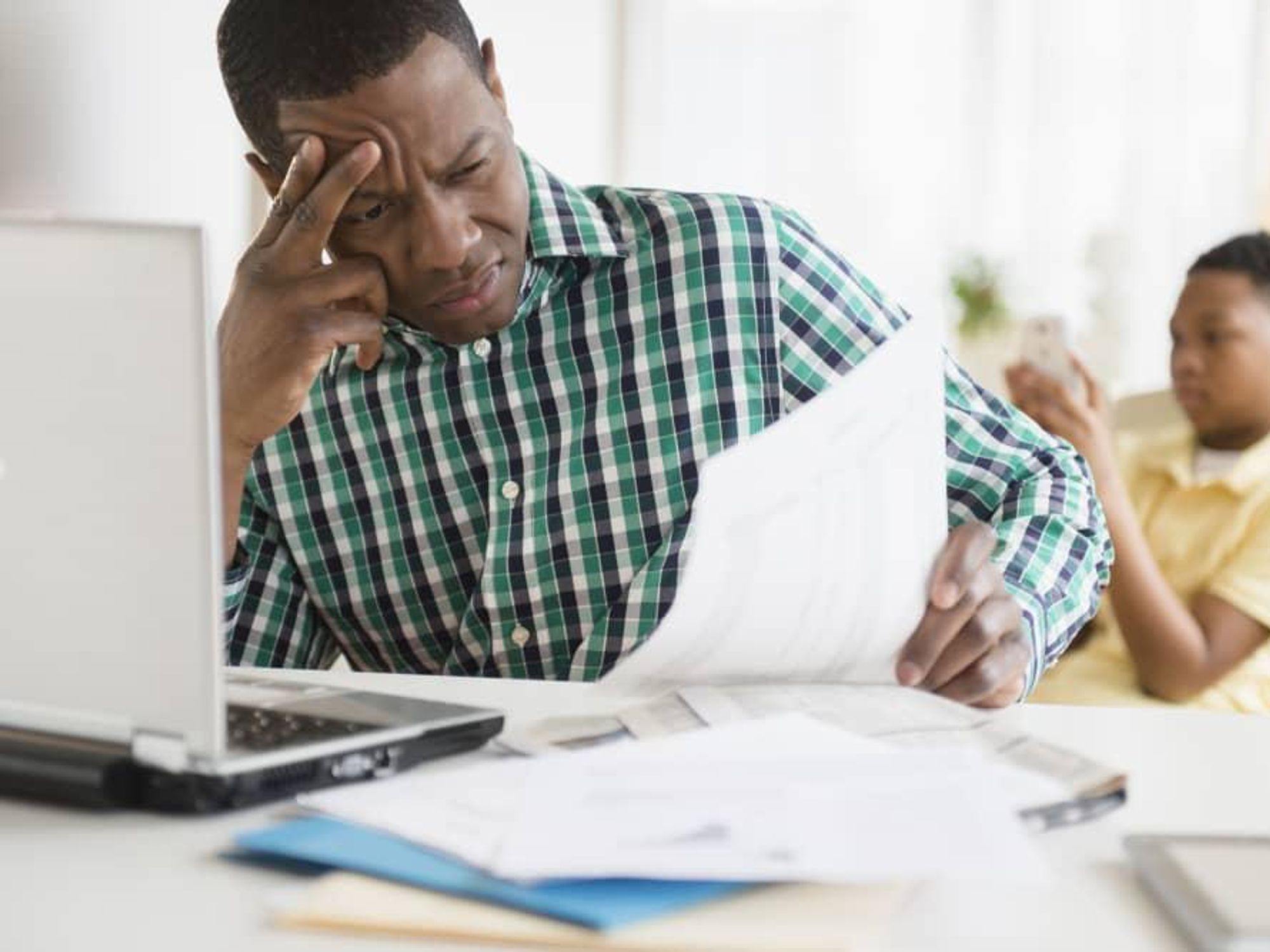 Man frustrated with paperwork and computer
