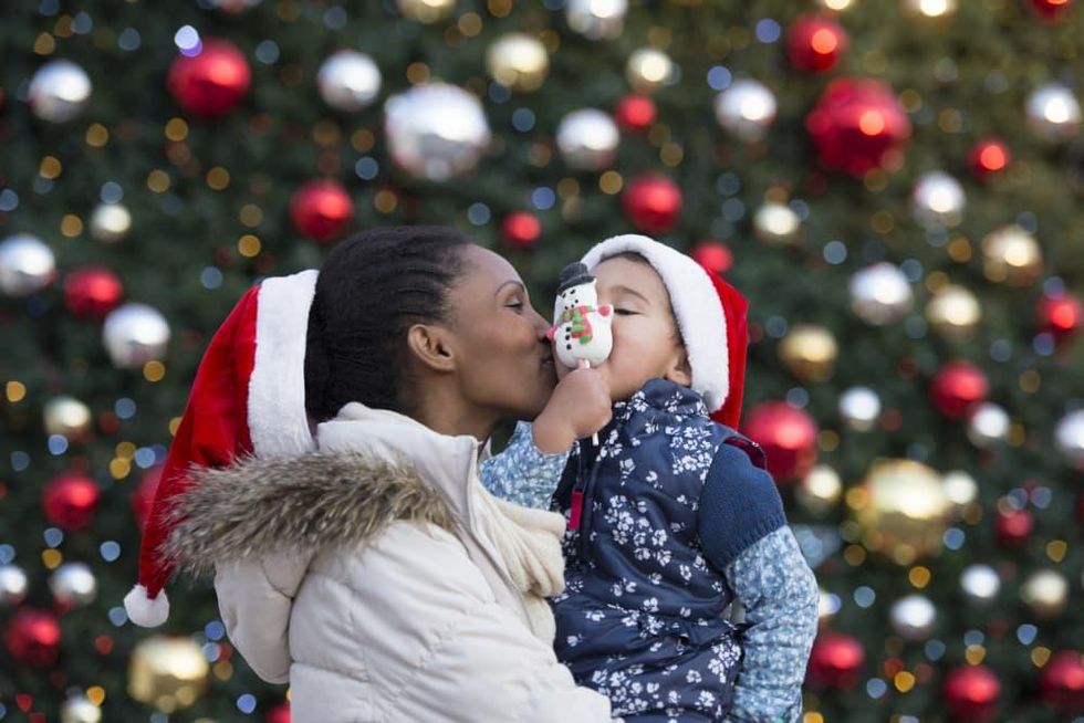 Mom kissing kid at Christmas