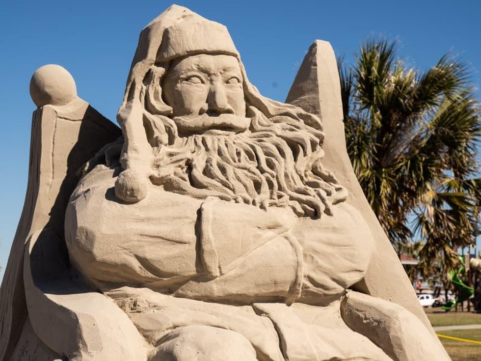 Santa Claus sand sculpture with kids