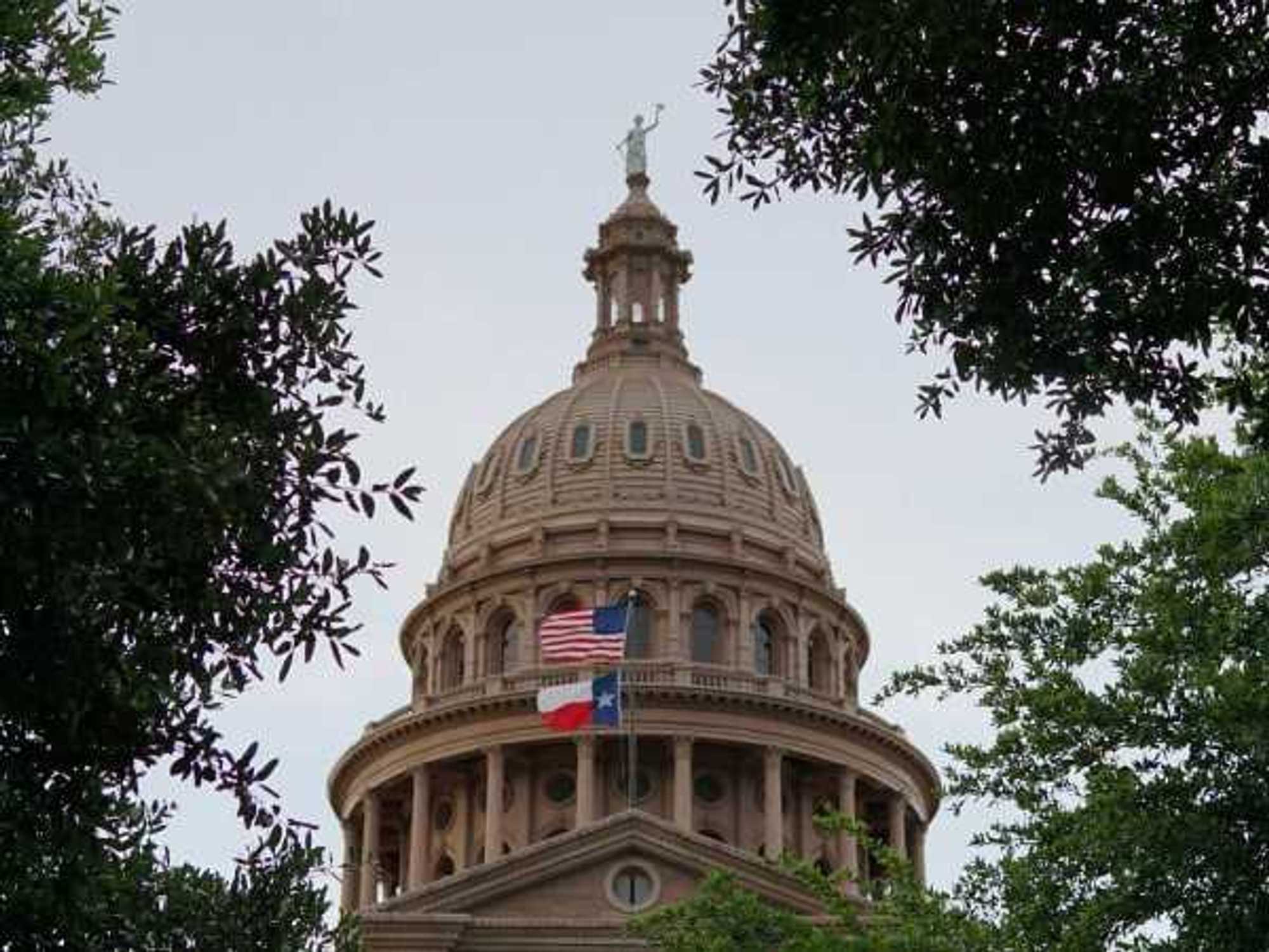 Texas Capitol building with state and US flags