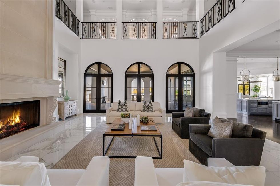 The open-floor plan showcasing the living room, fireplace, kitchen, and second-floor hallways.