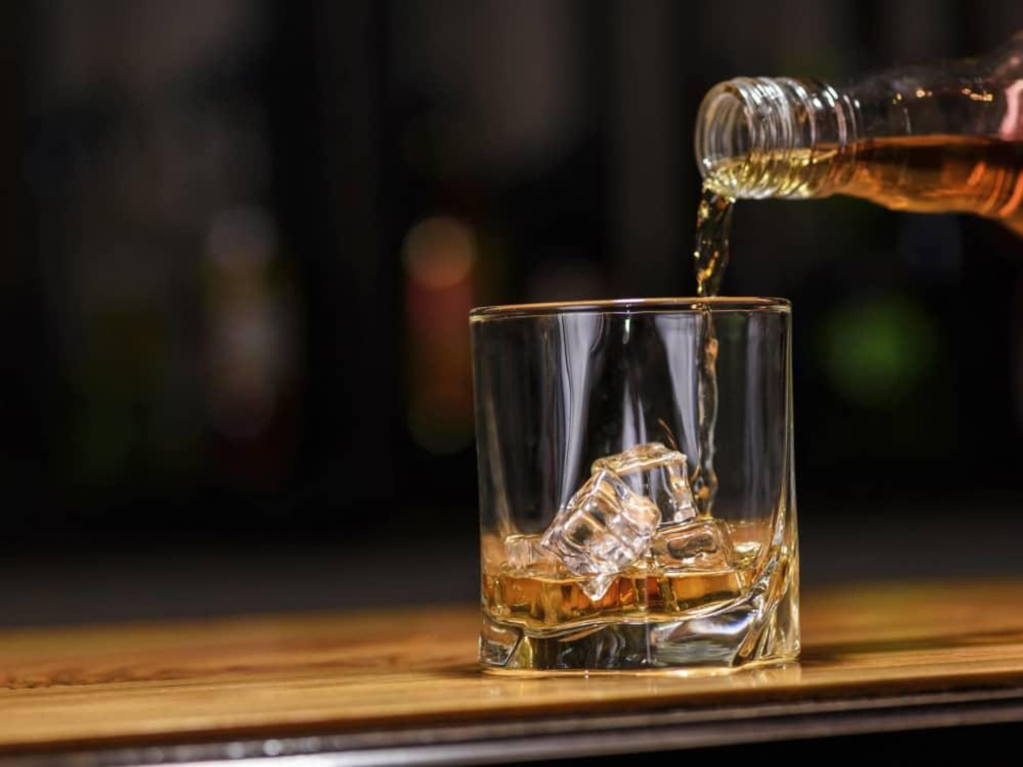 Whiskey being poured from a bottle into a glass